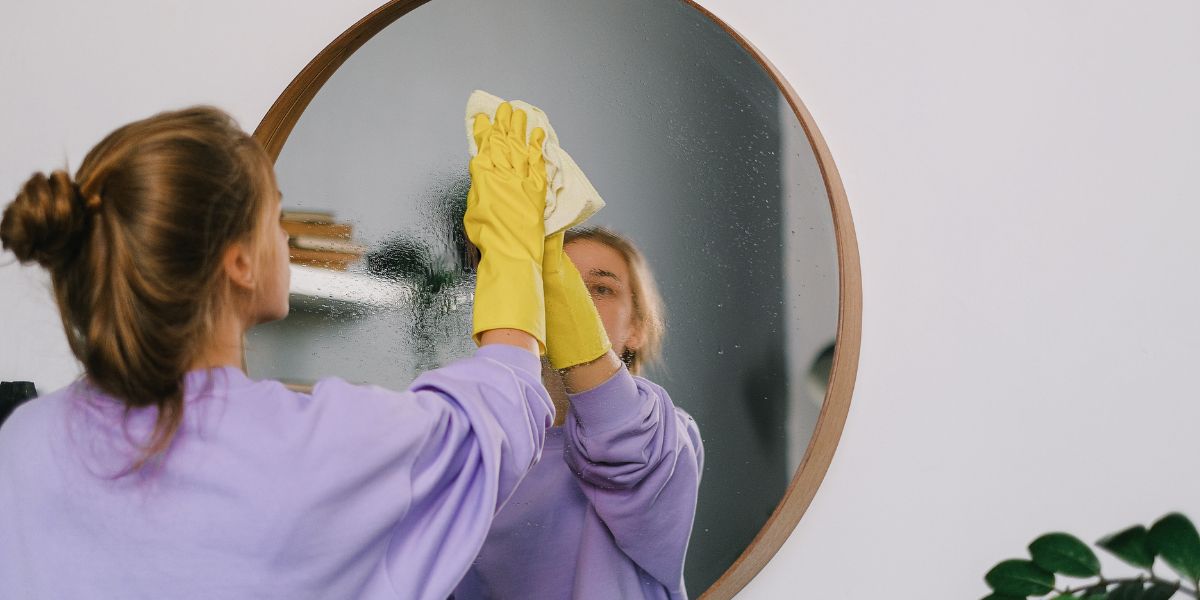 lady cleaning a mirror